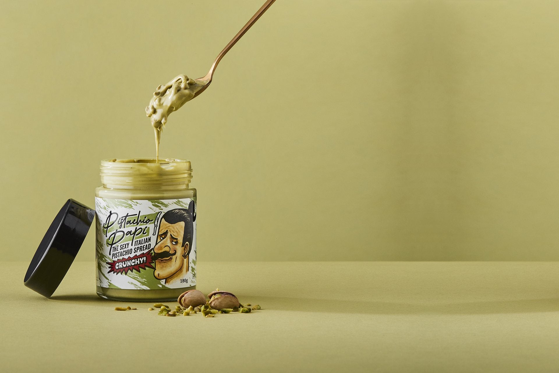 Pistachio Papi Crunchy Spread 180g — spoon dipping into the jar
